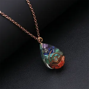 Macro view of teardrop orgonite necklace with multi-colored stones and copper spiral