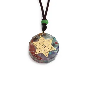Detailopname van levensboom hanger met chakra stenen en gouden Merkaba-symbool