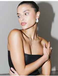 Detail of elegant water wave necklace set on model with a polished minimalist aesthetic