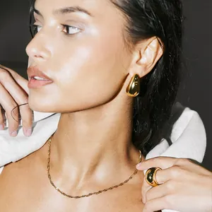 Elegant gold water wave chain necklace and teardrop earrings set on female model