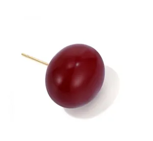 Dettaglio macro dell'orecchino a perno ovale rosso con finitura dorata di lusso