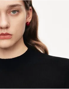 Primo piano di una modella che indossa orecchini a perla bordeaux in stile retrò francese