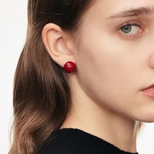 Orecchini a perno con perla rossa rotonda stile vintage francese indossati da modella