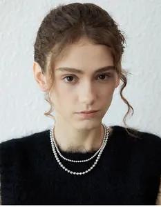 Close-up of double-layered silver bead necklace on model with black textured top