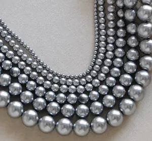 Macro detail of layered metallic grey pearl necklace with gradient sizing on vintage canvas