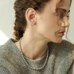 French retro silver metal bead necklace and stud earrings set on model neck