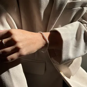 Bracelet tennis de luxe avec zircons porté par un mannequin en veste de costume à rayures