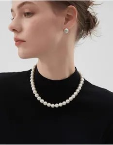 Détail d'un collier de perles rondes brillantes et boucles d'oreilles sur un modèle