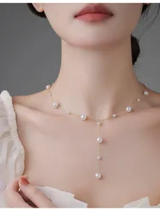 Detail of elegant Y-shaped gold pearl necklace with tiered layers on a model neck
