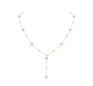 Detailed view of elegant Y-shaped gold pearl necklace with polished white round pearls
