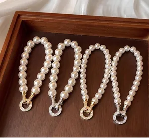 Macro view of four elegant round white pearl bracelets with gold and silver crystal clasps
