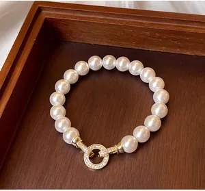 Detailed shot of white pearl bracelet with gold rhinestone-encrusted OT toggle clasp