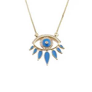 Golden evil eye necklace with micro-paved crystals and blue enamel detail on a box chain