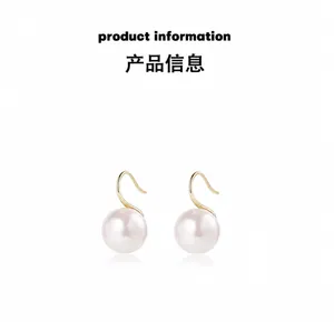 Macro di orecchini con perle tonde minimaliste e ganci dorati a forma di S eleganti