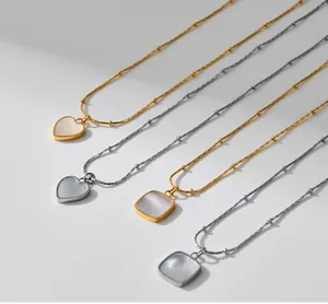 Detalle de collares de nácar vintage en forma de corazón y cuadrado en oro y plata