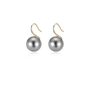 Detail view of round grey pearls on elegant S-shaped golden metal earring hooks