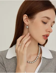 Close-up of elegant grey pearl jewelry set including necklace, earrings and diamond ring