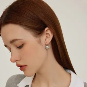 Minimalist S925 sterling silver hook earrings with round grey pearls on a female model