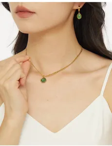 Close-up of a model wearing the gold-plated aventurine pendant necklace and matching earrings