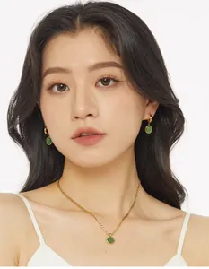 Close-up of elegant gold necklace and matching green aventurine earrings on model