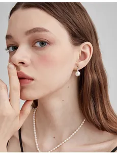 Close-up of elegant grey round pearl earrings and necklace set on a model