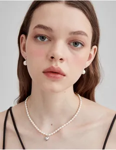 Close-up of elegant pearl jewelry set featuring a heart pendant and matching earrings
