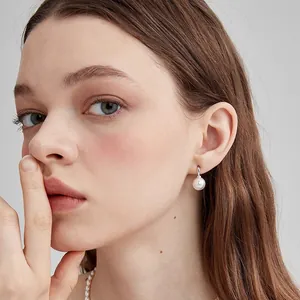 Elegant C-shaped French vintage round pearl drop earrings with silver hoop on model