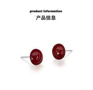 Gros plan d'élégantes boucles d'oreilles perles rouges avec finition polie et tiges