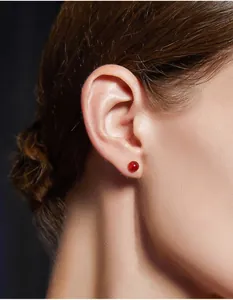 Primo piano dell'orecchino a perno in agata rossa indossato con stile su una modella
