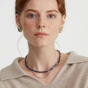 Eleganti orecchini ottagonali in cristallo e collana a strati su una modella donna