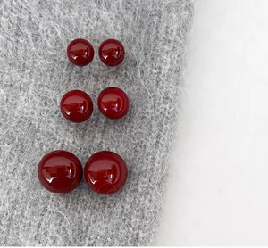 Vue détaillée de trois paires de boucles d'oreilles rouges brillantes de tailles variées