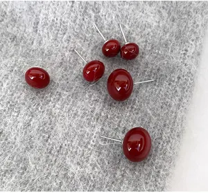 Vue détaillée de boucles d'oreilles perles rouges brillantes sur fond velouté
