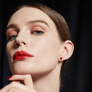 Orecchini a perno minimalisti in agata rossa per donna indossati su una modella