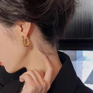 Vintage irregular double-layered gold hoop earrings with twisted metal texture on a model