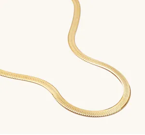 Makroaufnahme der eleganten flachen Schlangenkette mit polierter Goldbeschichtung