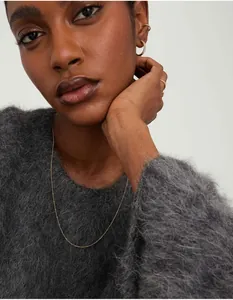 Close-up of minimalist 18K gold-plated necklace and earrings worn on a model
