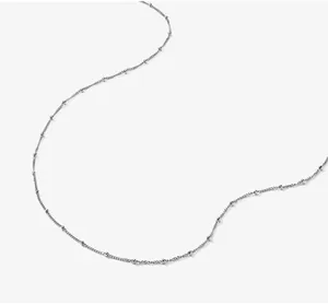 Detailed close-up of a silver curb chain necklace with minimalist polished metal beads
