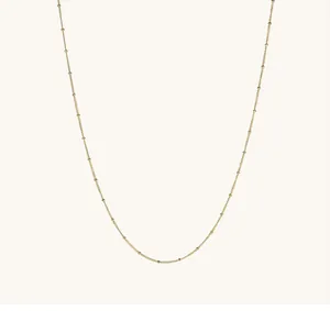 Detailed view of an 18K gold-plated titanium steel saturn chain with delicate beads