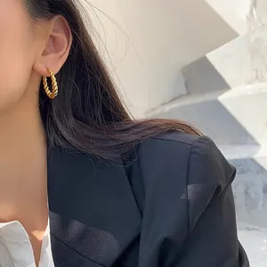 French vintage twisted gold hoop earrings shown on a model in black blazer