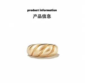 Macro shot of gold croissant ring featuring detailed textured spiral design and shiny finish