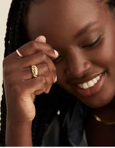 Detail of croissant dome ring set on hand featuring twisted rope and minimalist gold band