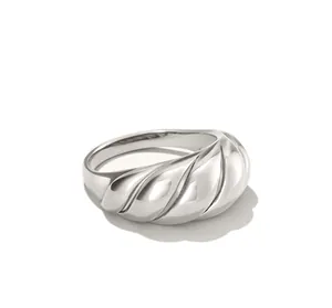 Macro detail of silver croissant dome ring showing twisted texture and polished finish