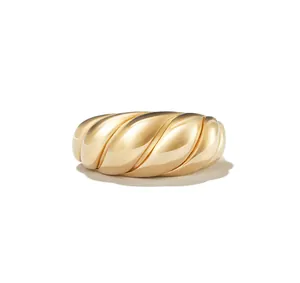 Close-up of a polished gold croissant dome ring with twisted texture and minimalist design