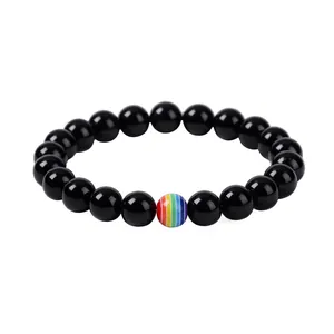 Macro detail of polished black lava beads bracelet with a vibrant rainbow striped bead