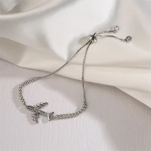 Close-up of adjustable silver bracelet with colorful cubic zirconia airplane pendant
