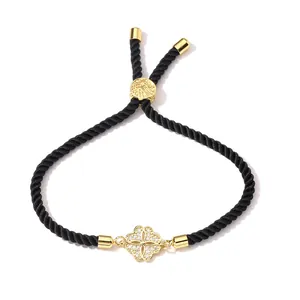 Adjustable woven black rope bracelet featuring a gold clover charm with sparkling zircons