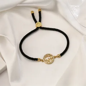 Detailed shot of golden family silhouette pendant with zircon on adjustable black rope