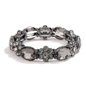 Elastic crystal bracelet featuring smoke grey oval stones and gunmetal floral accents
