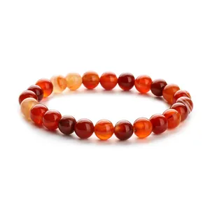 Natural red agate beaded bracelet with polished round carnelian stones on white background