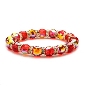 Faceted red and yellow crystal bead bracelet with gold rhinestone spacers on white background